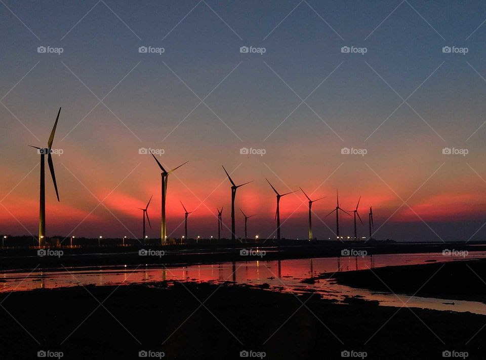 Silhouettes and shadows: windmill blvd. of Gaomei wetland. crepuscular rays of sunset.