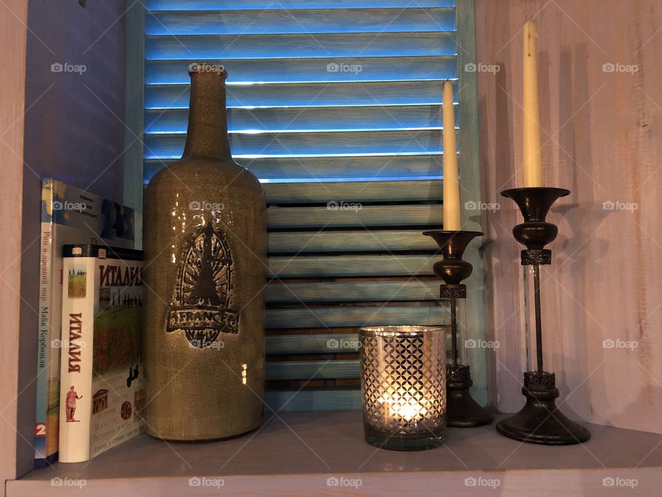 Interior design with candles, books and bottles 