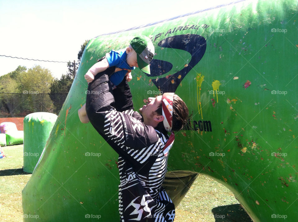 A proud daddy playing with his son after a paintball practice