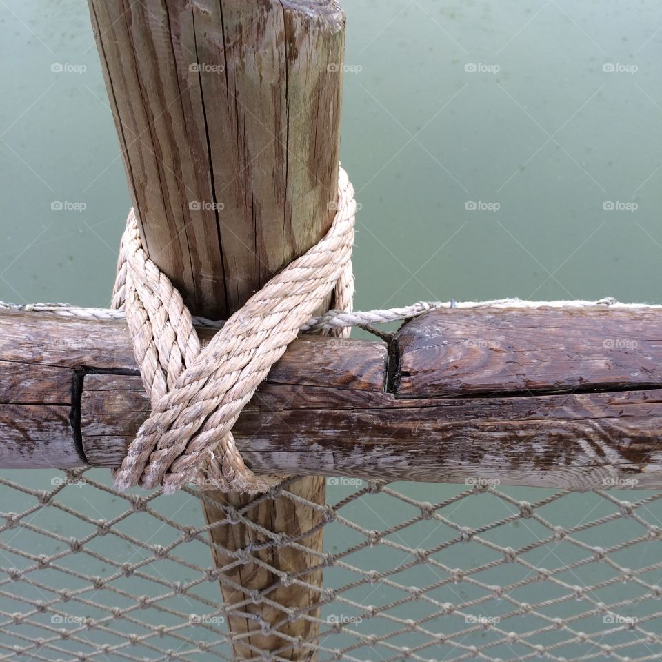 Knot on the Lake. Rope knot on fence by the lake