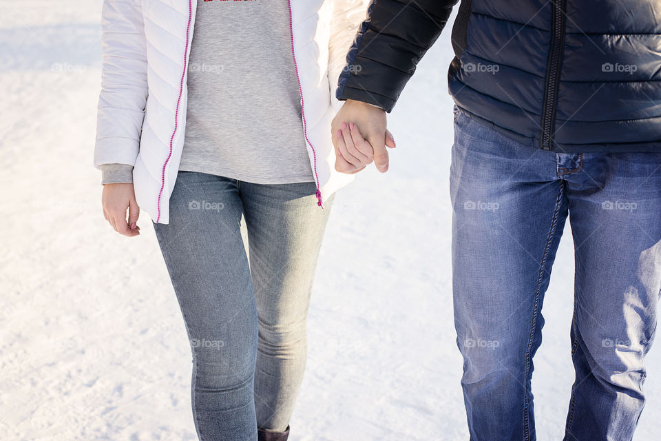 Midsection of couple holding hands outdoors