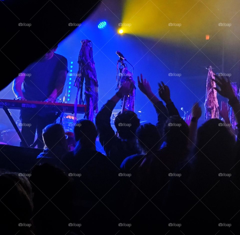 crowd of enthusiastic people dancing in a dark Portland Oregon concert venue while the band plays music on-stage