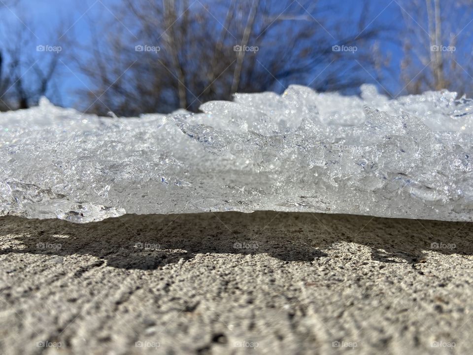 Ice over sidewalk, starting to melt and viewed from a different angle