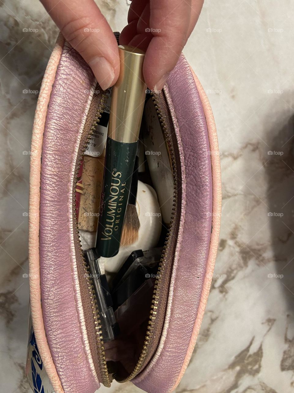 Putting my favorite L’Oréal Voluminous Mascara in Deep Green in my makeup bag, which also contains foundation, makeup brushes, a compact and eye shadows. The bag is from Box Lunch, which partners with Feeding America to get food to people in need.