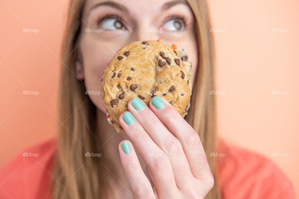 Woman taking a selfie with a chocolate chip cookie sandwich