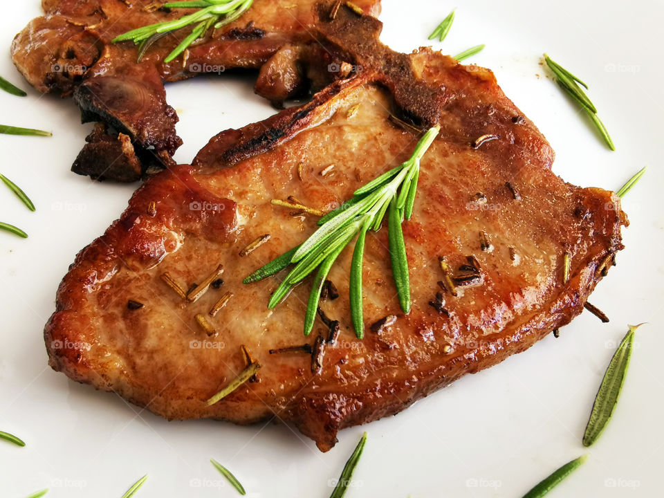 Pan fried pork chops on a white plate. Concept for Keto diet and healthy food.