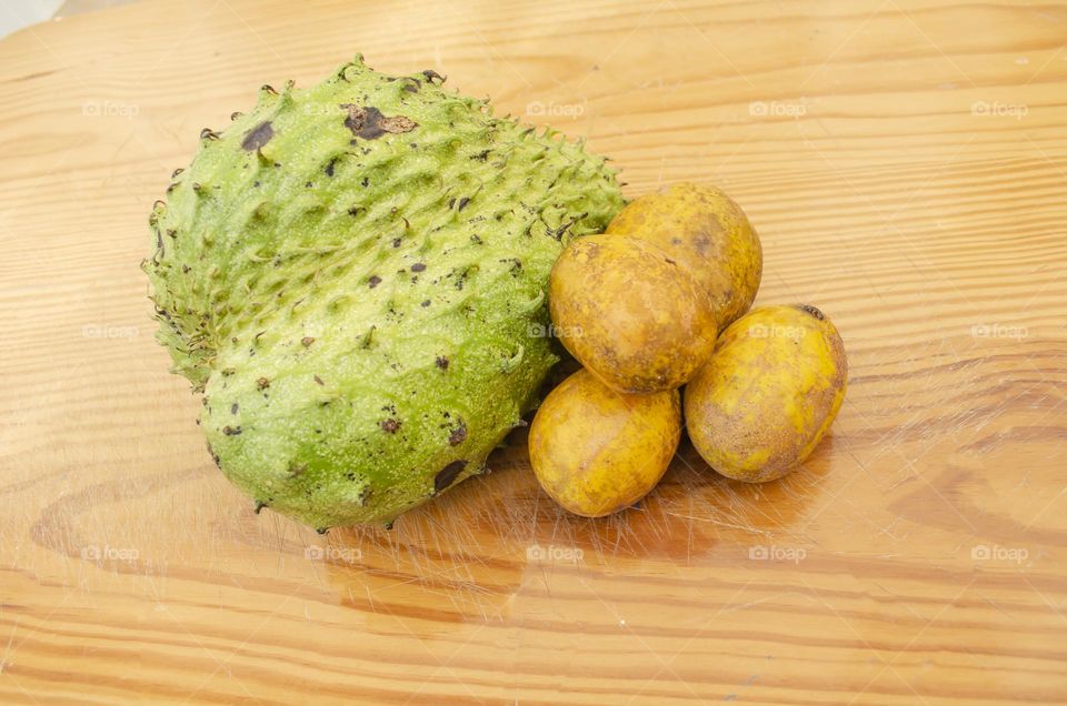 Soursop And June Plums On Wooden Surface