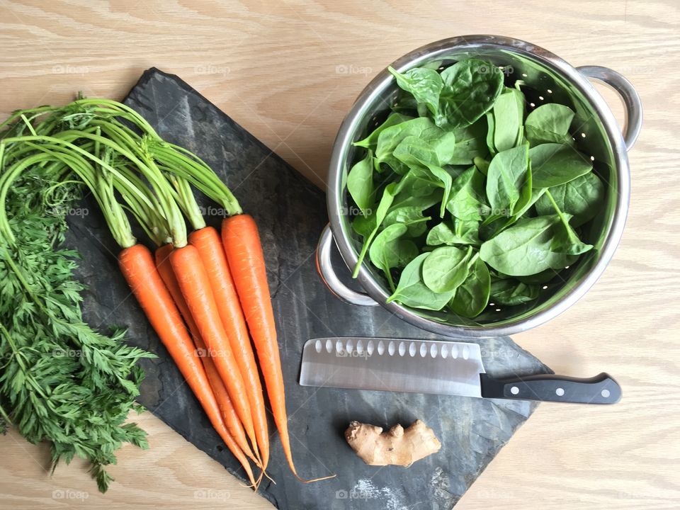 Cooking with fresh vegetables; baby spinach, organic carrots, ginger root. Healthy spring time meals.