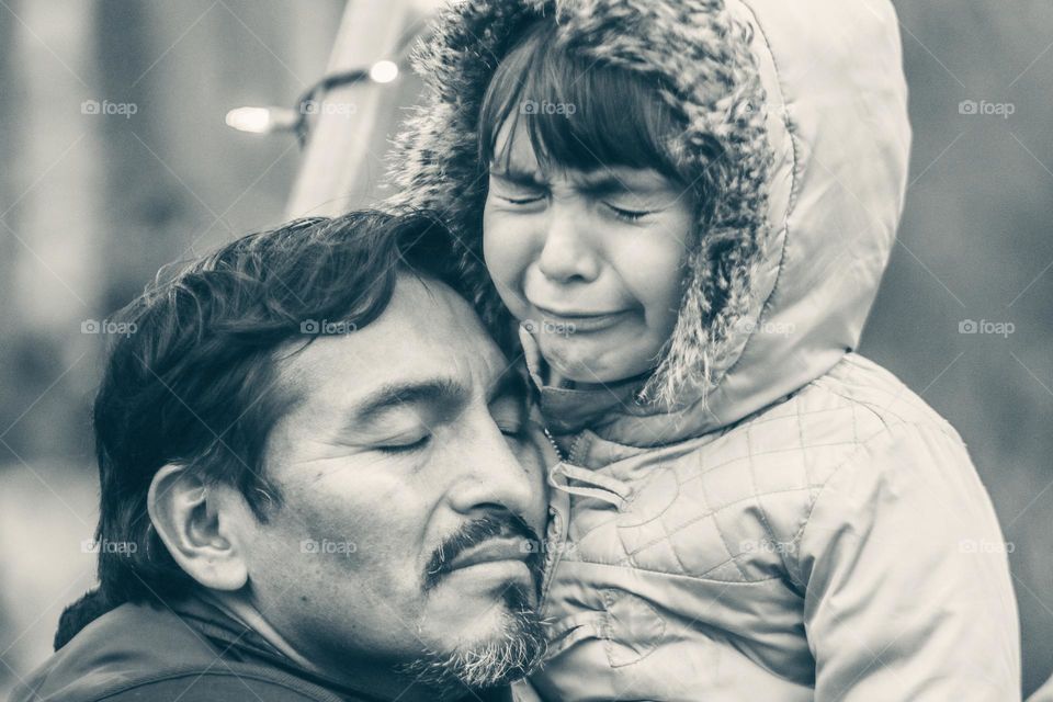 Crying girl and her father who is trying to comfort her