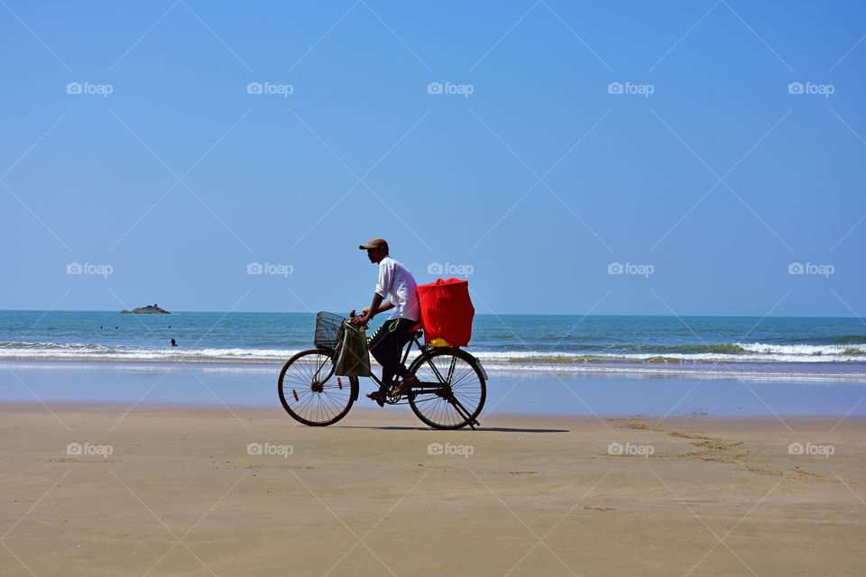 salesman on his bicycle in a beach