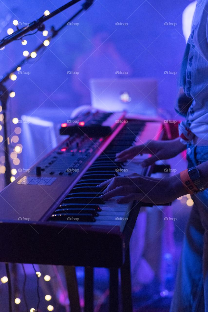 Musician playing on a keyboard. Concert lights. LIVE music. 