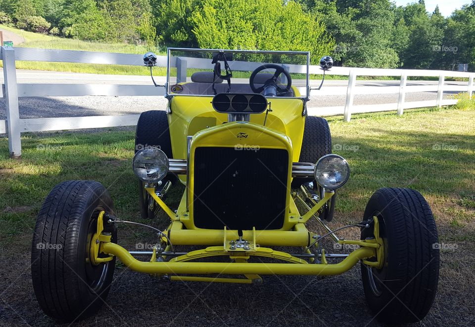 a classic yellow custom Ford hot rod convertible.