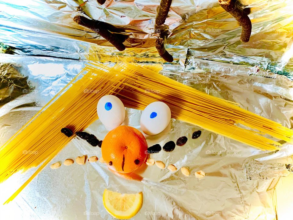 Food Funny Creature Looking At Treats Eyebrows Made Of Spaghetti, Eggs, Clementine, Lemon, Raisins, Peanuts And Dog Treats. 