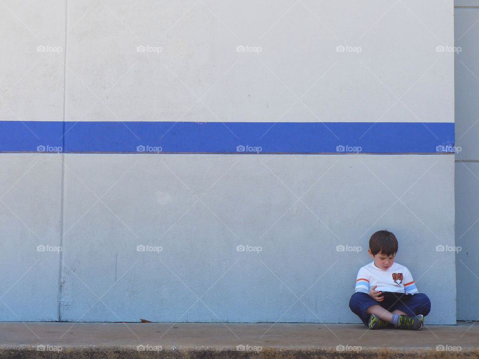 Kid gaming portable device. Kid gaming while awaits for mom to finish shopping
