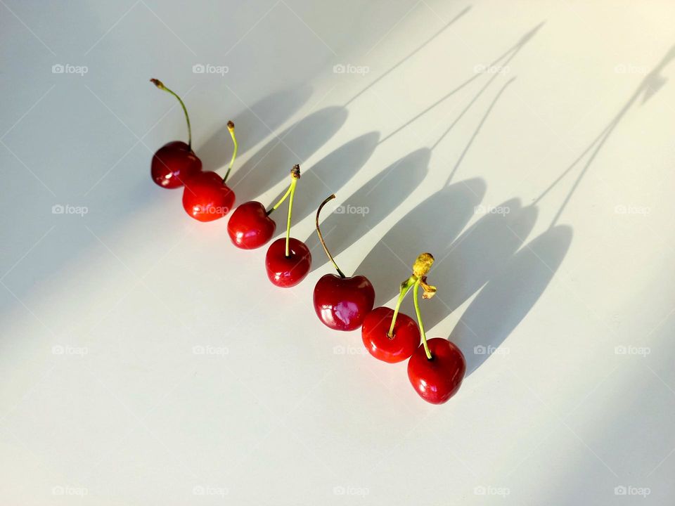 cherries and its shadow falling on the table.