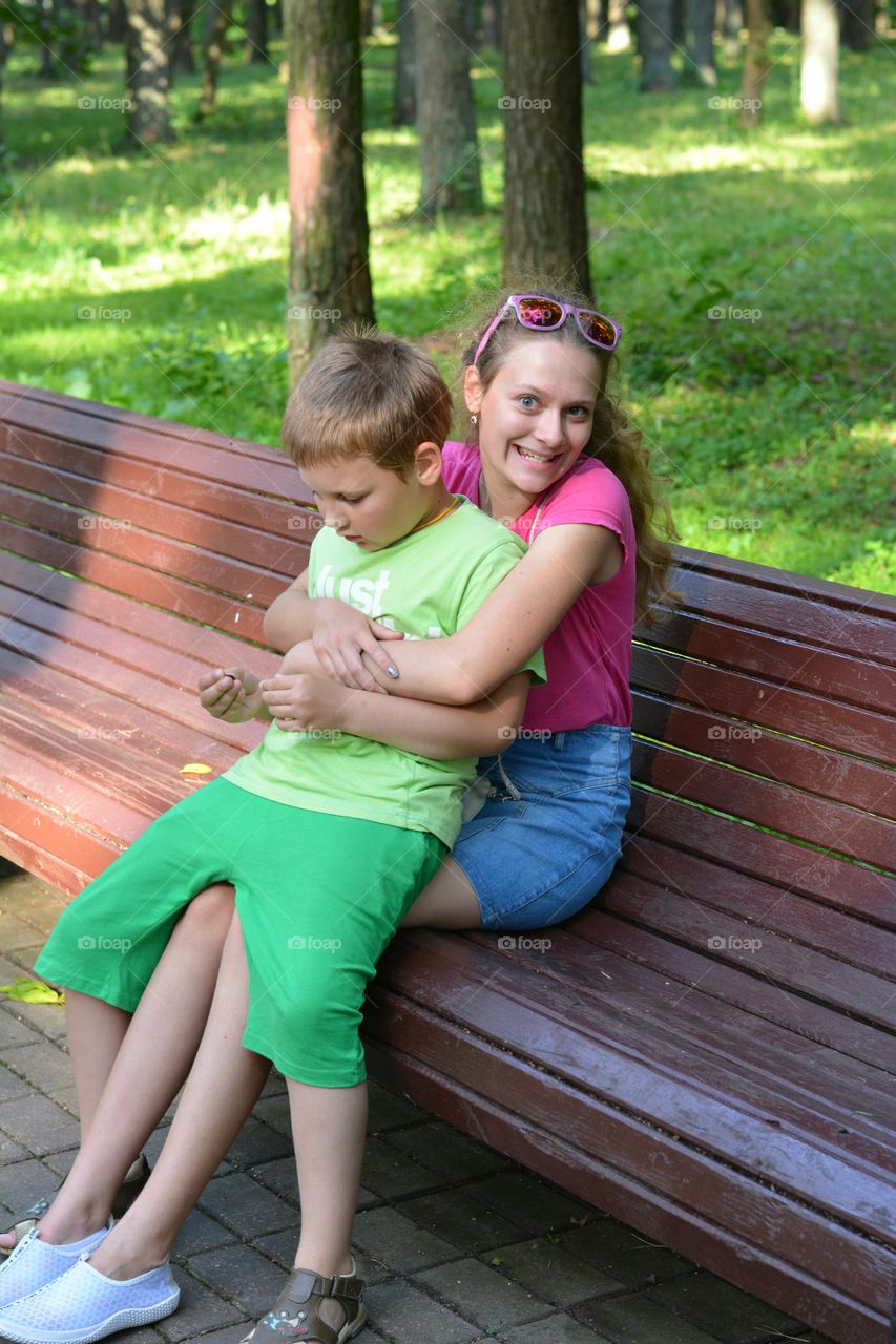 children on a bench in the summer city park