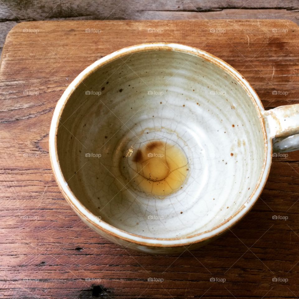 empty coffee cup with a smiley face on wooden table