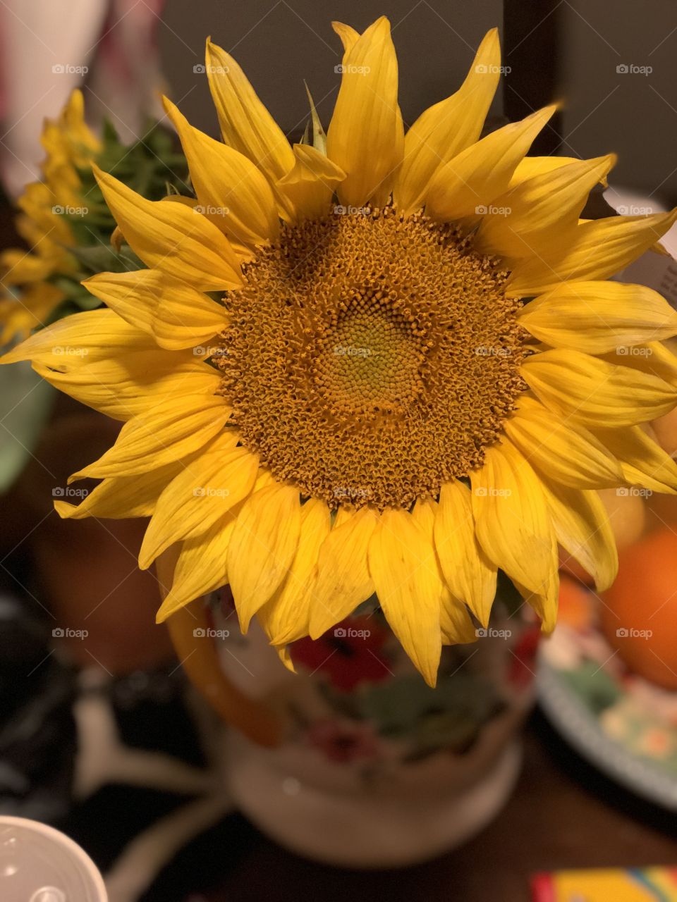 Close up of a single  yellow sunflower in a pioneer woman vase.