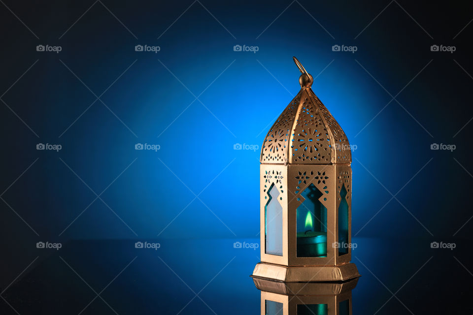 Antique golden lantern for eid or Ramadan celebrations on blue background