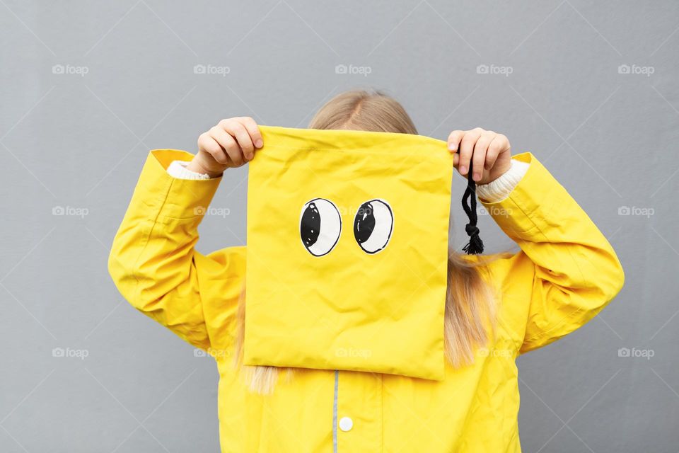 Funny photo of kid in yellow raincoat 