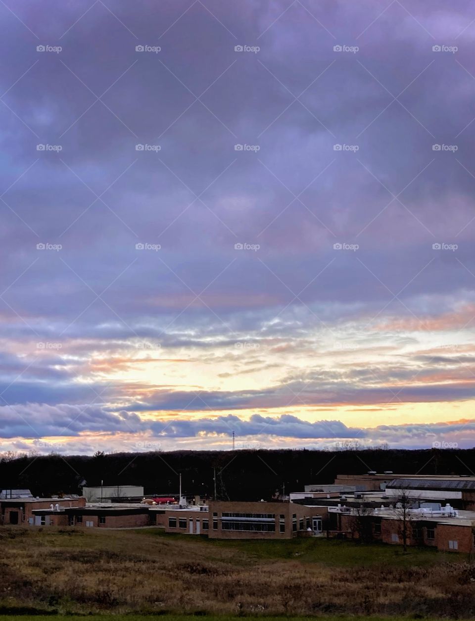 Sunset over a school in a rural town in midwest Michigan turning the sky and clouds purple, pink and orange