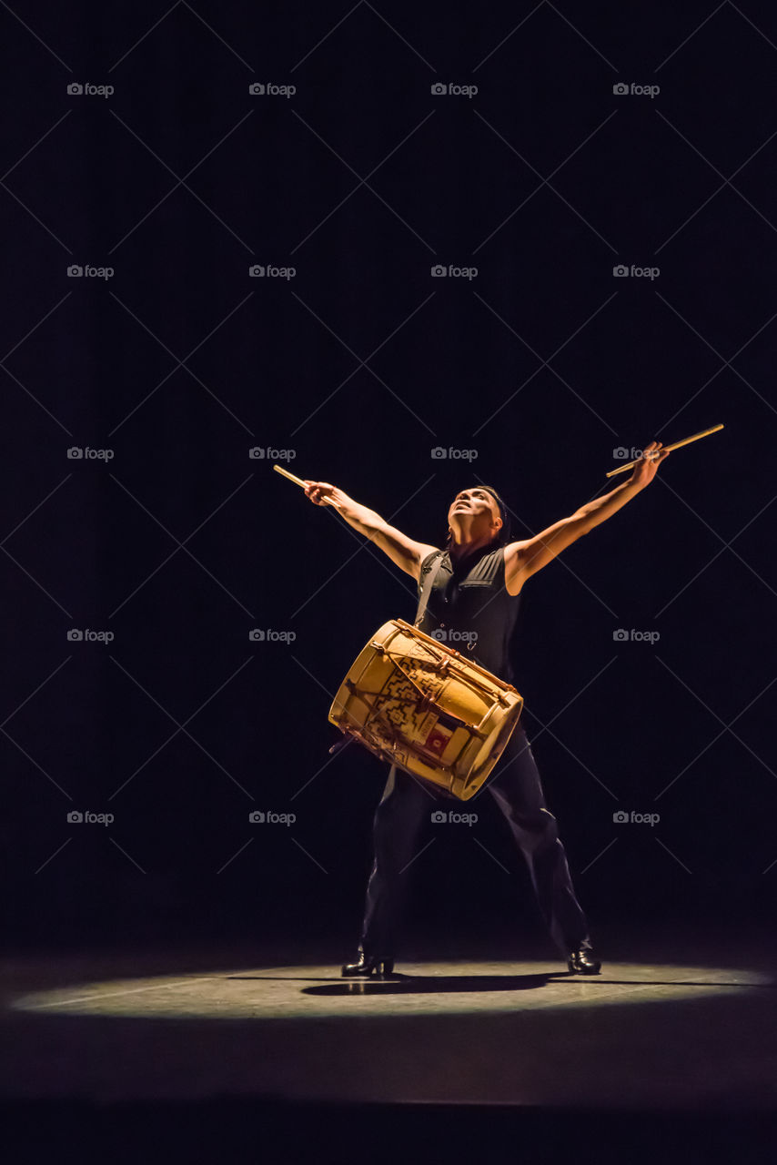 Drummer performance finishes in grand style with arms raised. 