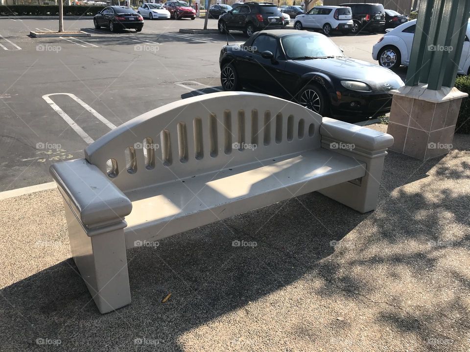 A public bench in the parking lot area.
