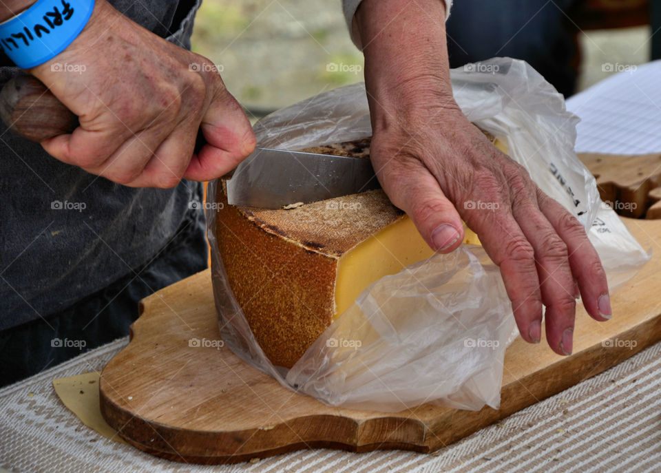 Experienced hands. White goat's milk cheese beinh cut by the experienced cheese maker at the goat cheese festival in Undredal, Norway