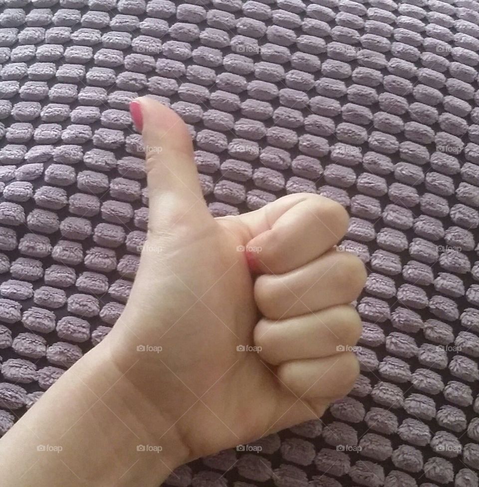female thumb up with a purple texture background