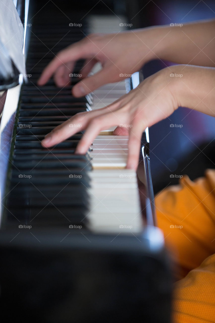 Concentrated, delicate hands working on a piano