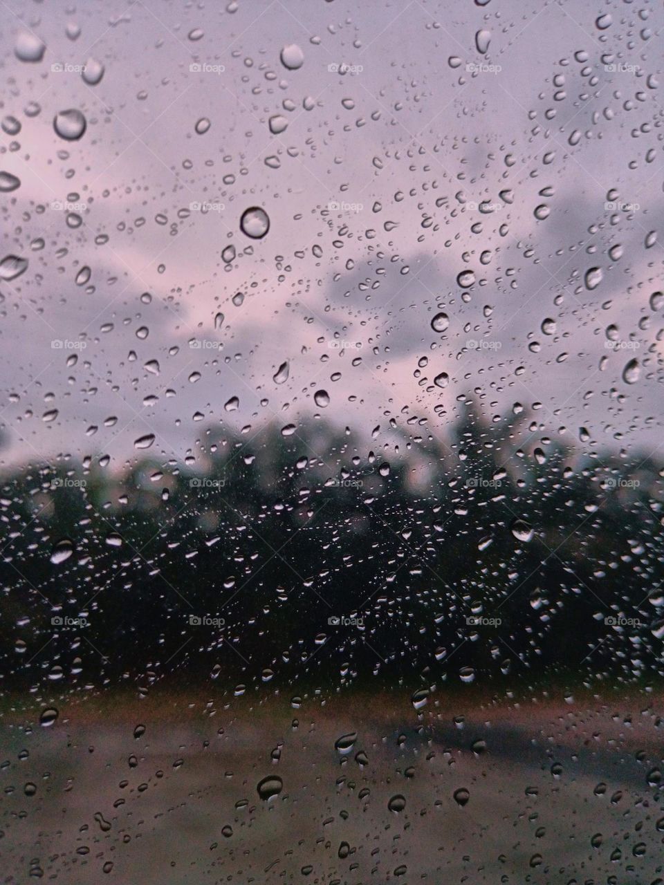 Selective focus on the rain drops on the windshield of the car. After rain at the rainy season