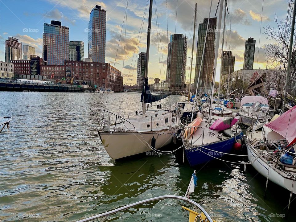 This is “Newtown Creek” by the “Pulaski Bridge” in LIC, Queens with various boats that are tied to the shore here. Tonight the “E River” is gleaming in bright silver enhanced by the silver clouds that reflect from above. 2024. Hypnotic Productions