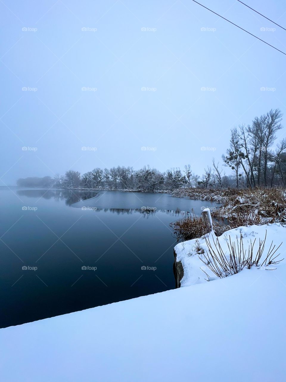Peaceful and calm, quite bank of the winter lake in the little village at the middle of February