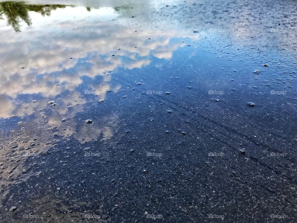 Asphalt reflection. Sky and clouds