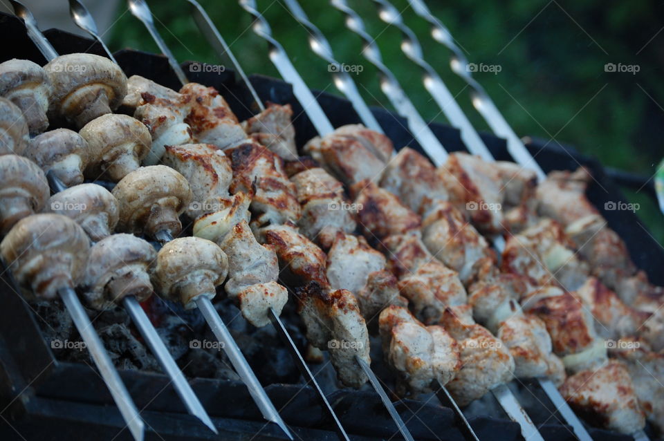 Kebabs and mushroom on charcoal barbecue