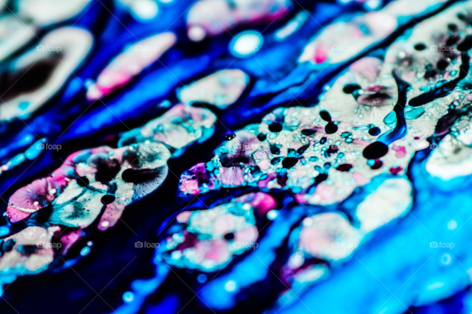 The ink to refill the printer cartridge was spilled onto the white washbasin and the paints blended into abstract drips and patterns.