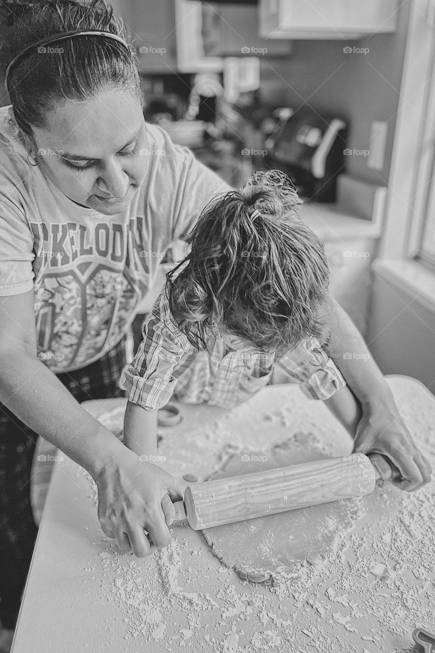 Mother helps daughter roll out cookie dough, using a rolling pin with mommy, toddler learns how to make sugar cookies, baking in the kitchen with mommy, fun in the kitchen with mommy