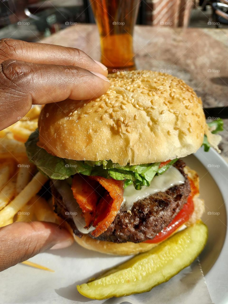 Taking hold of a delicious avocado bacon Burger in the downtown district of Sacramento California