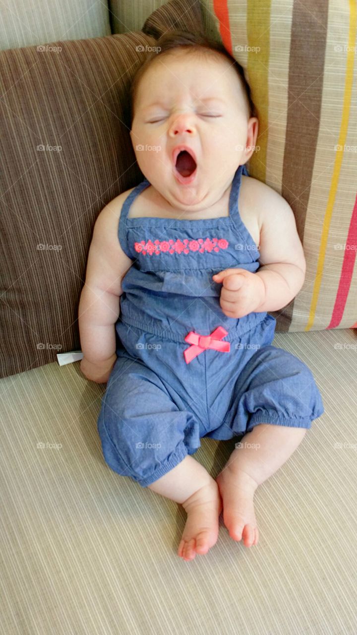 Front view of baby girl yawning