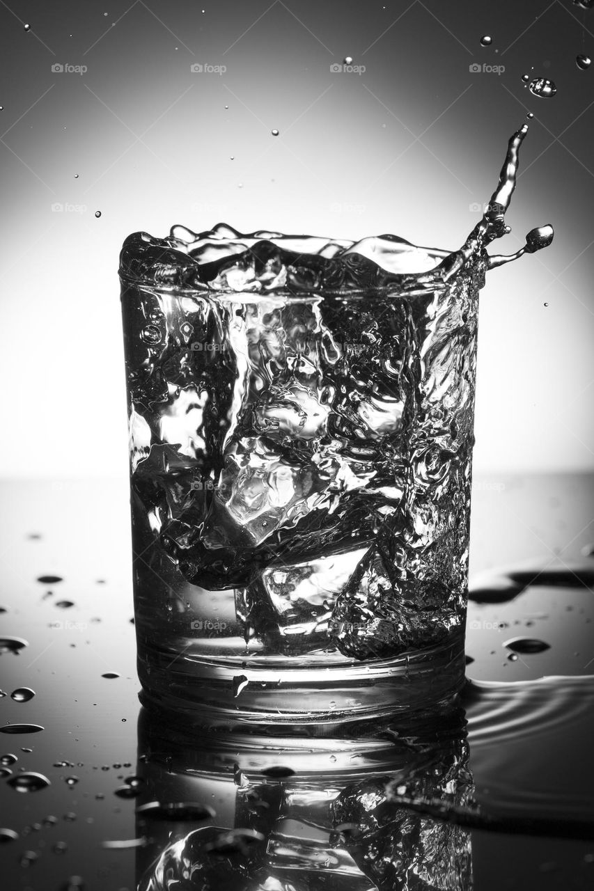 glass of water with splash from falling ice cubes