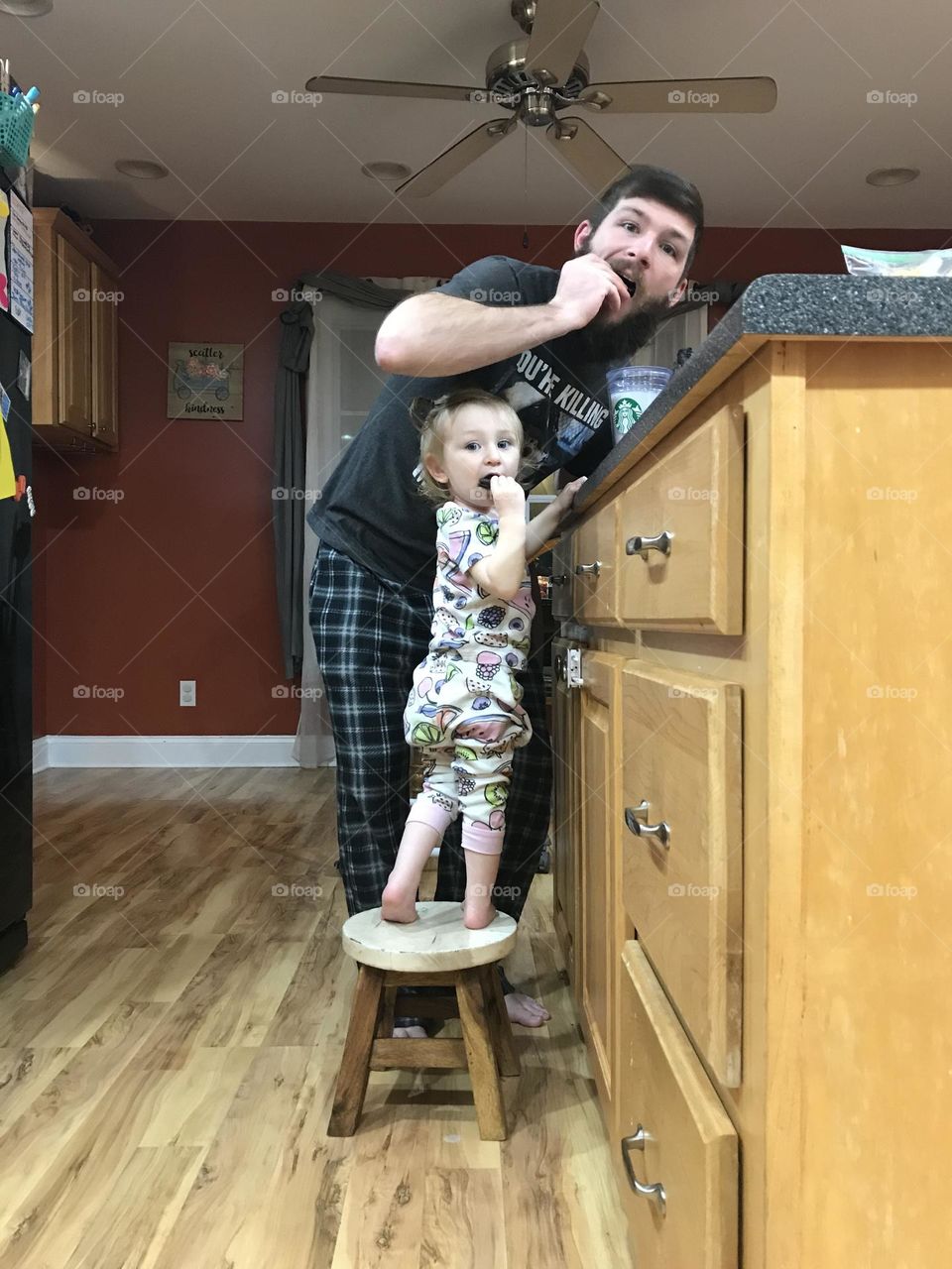 A dad and a baby caught eating cookies at bedtime. Funny photo! 