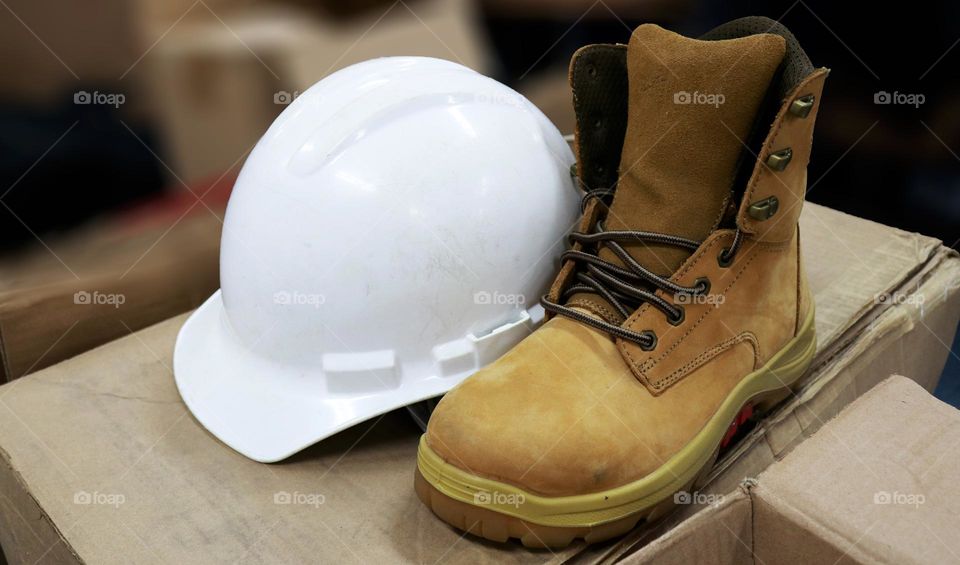 Photos of safety helmets and safety shoes for workers. This safety equipment is included in safety first to prevent work accidents