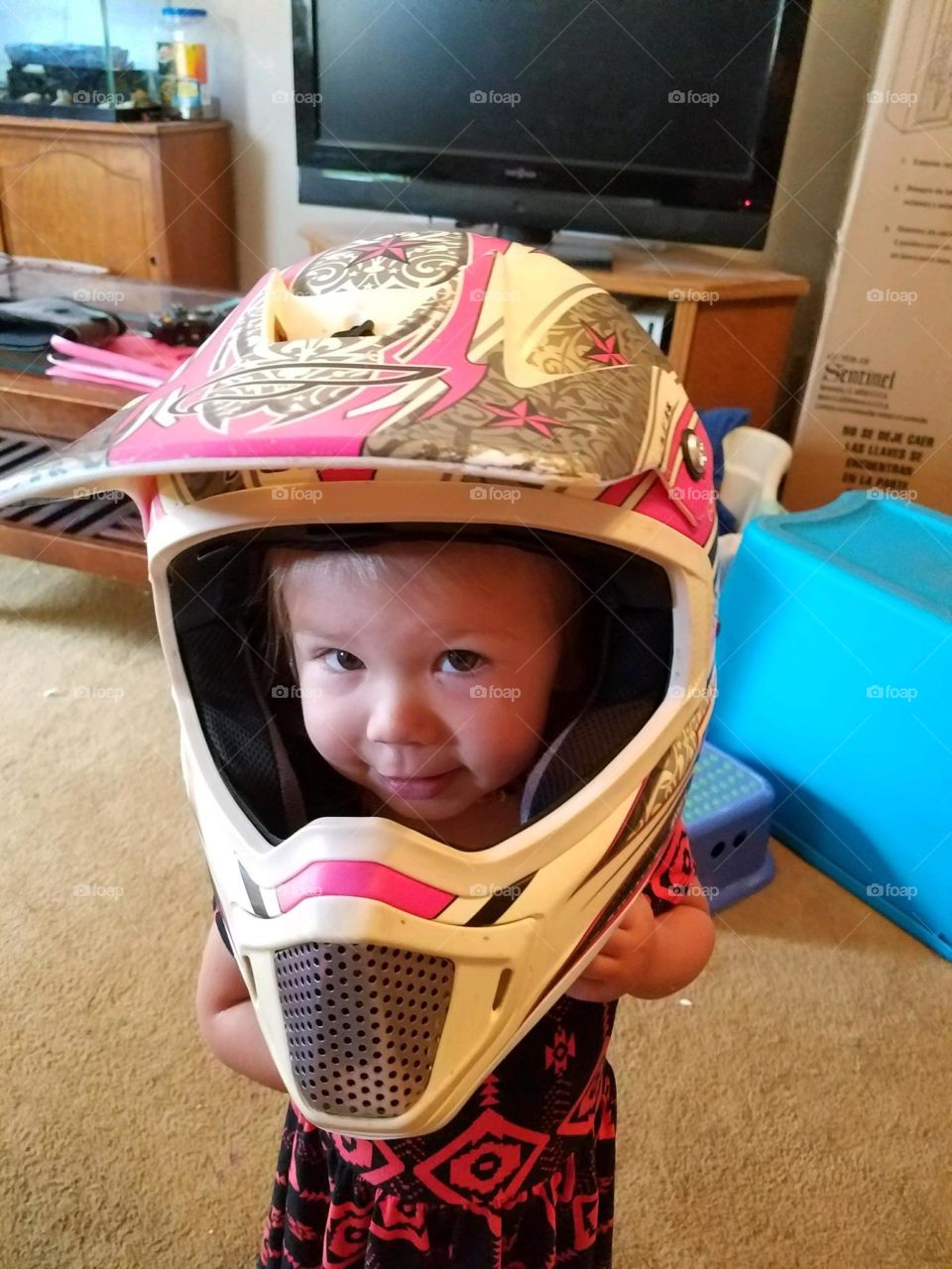 My adorable daughter this little girl trying on a helmet that is way too big for her but she wants to ride four-wheelers in Vidor Texas United States of America 2017