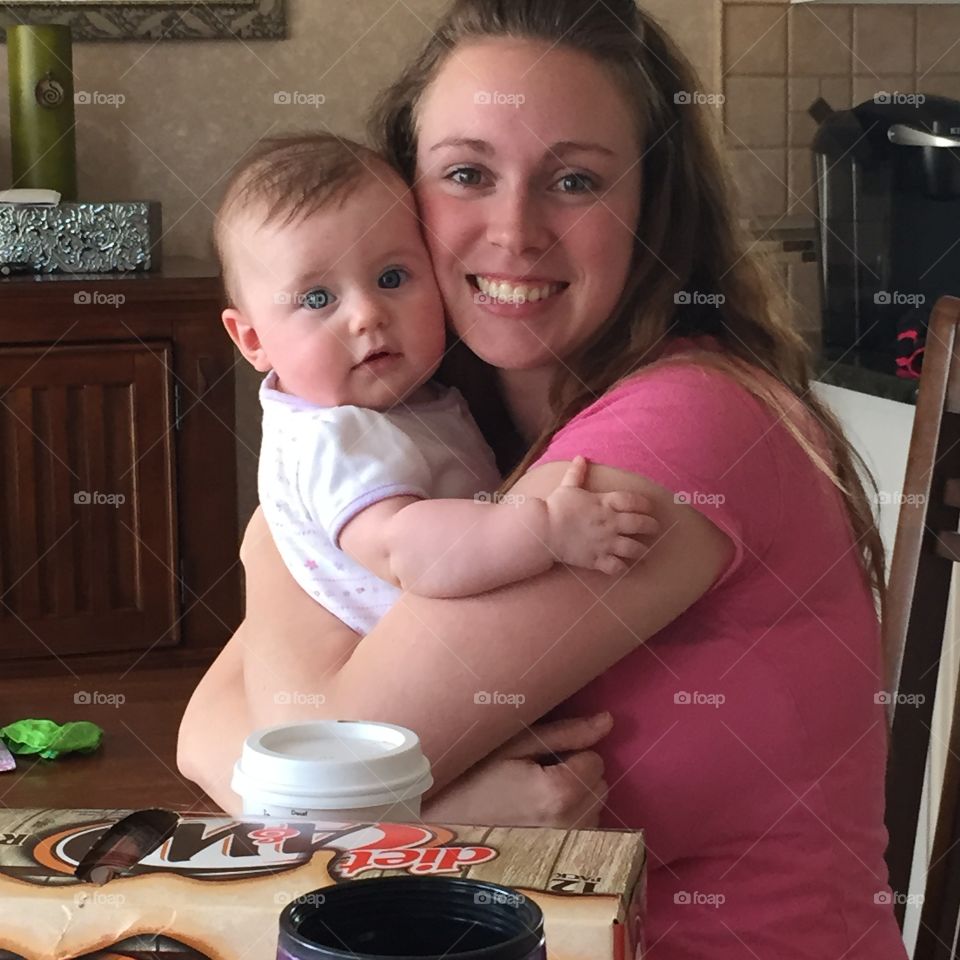 Woman sitting on chair and holding baby kid