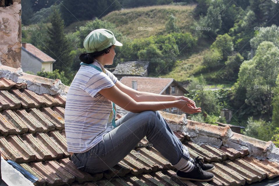 Young woman on the country house roof