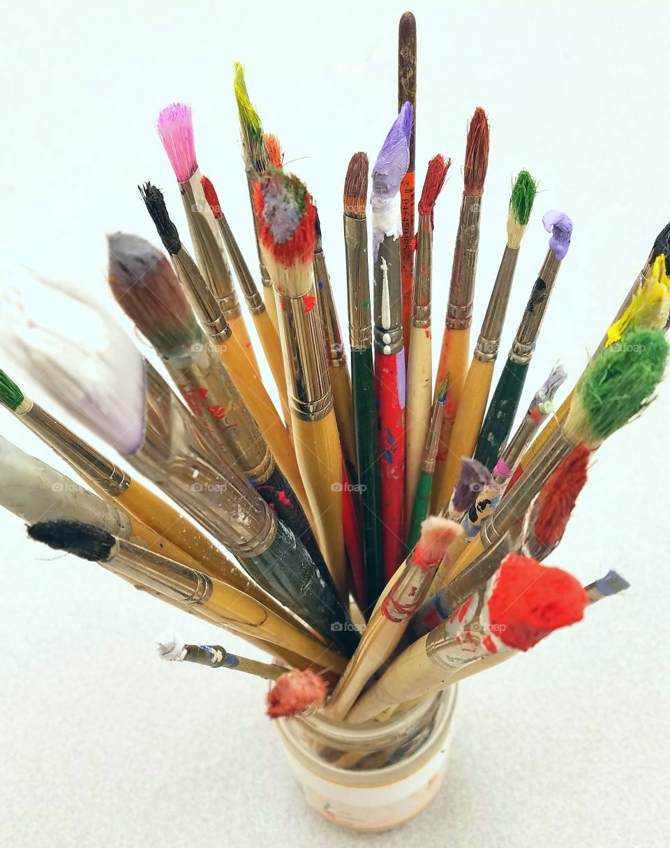 High angle view of messy paintbrushes