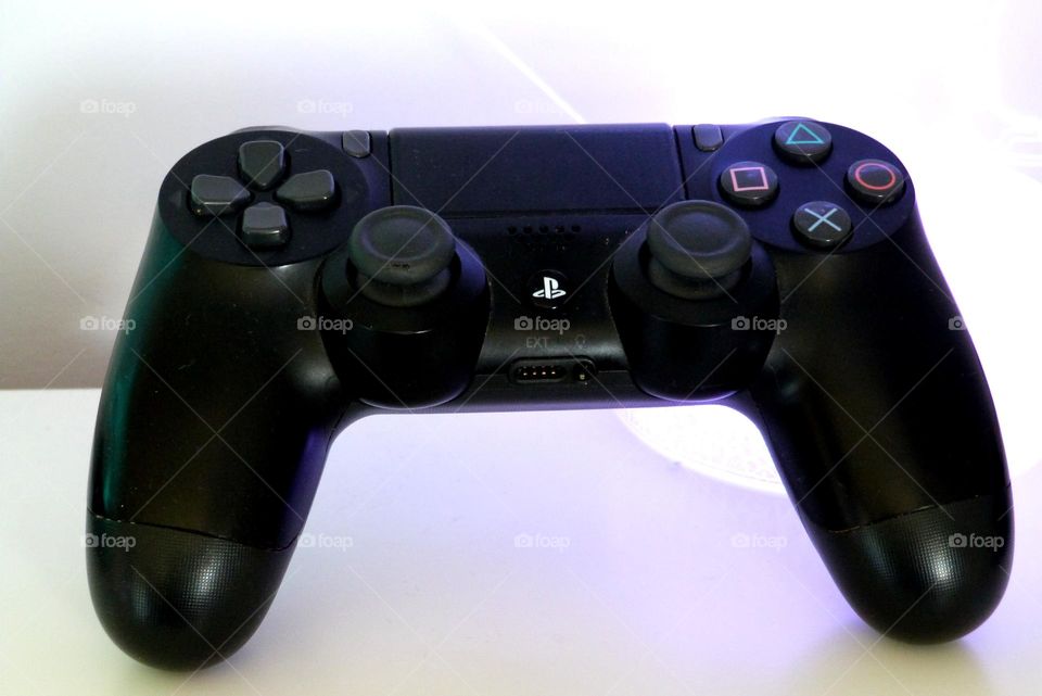 A PlayStation controller presented in front of light decorations.