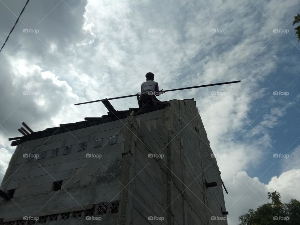 working at height: a craftsman is making a roof on a building