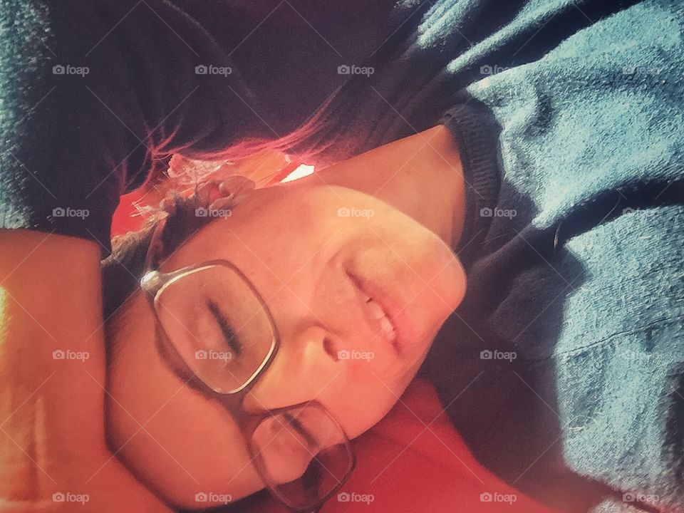 Girl with glasses in the sun with closed eyes 