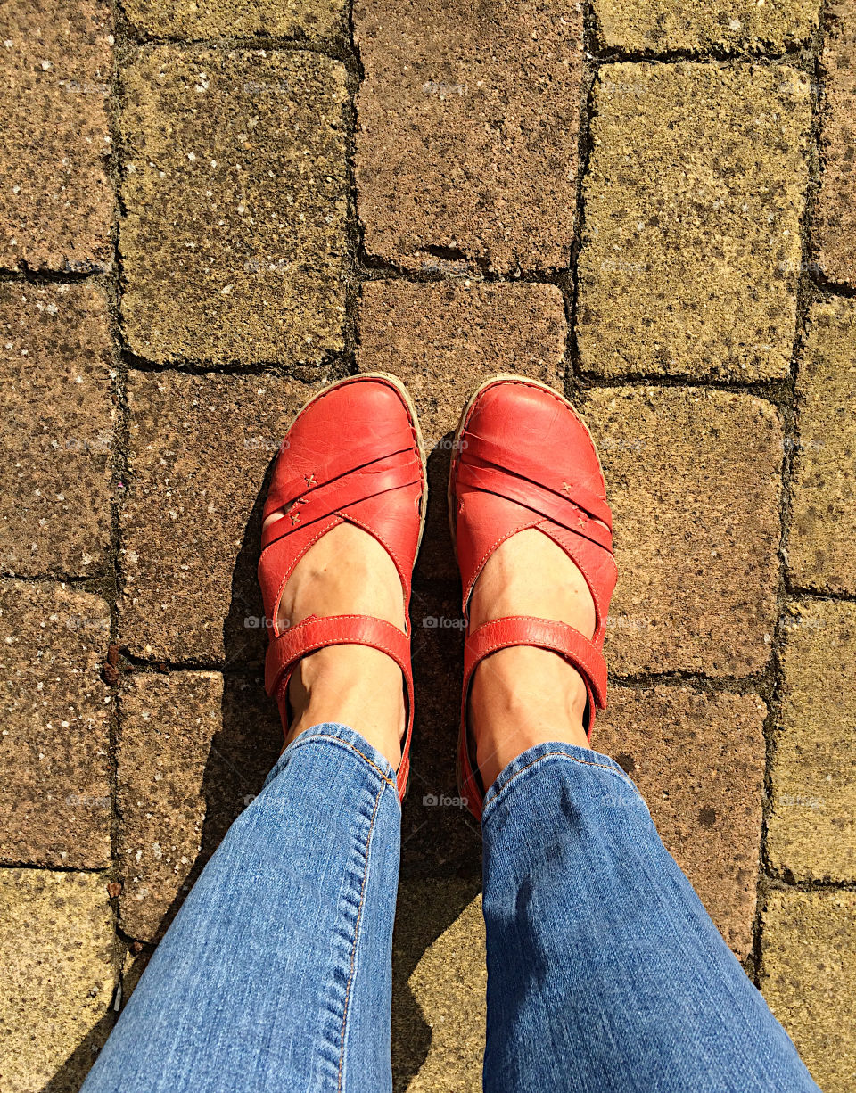 Standing with red sandals on the stones in my garden 